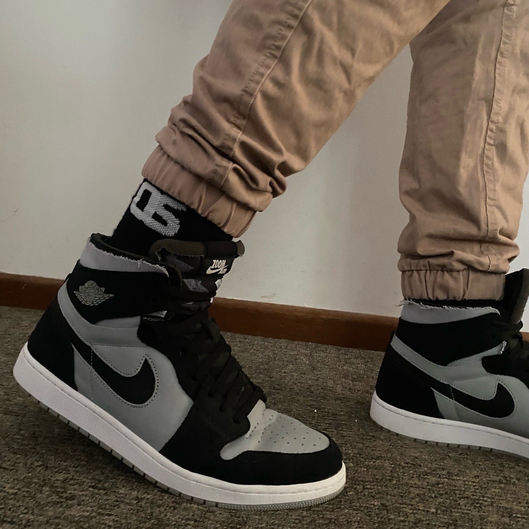 Australian Made Cotton Sock, shown in black with a white logo styled with tan pants and Jordan 1 shoes