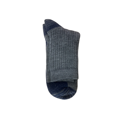 A pair of ribbed socks in Grey with navy blue accents on the toe & heel.